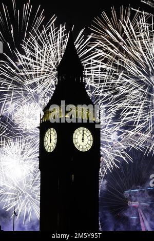 Fireworks illuminate the Elizabeth Tower (Big Ben) and the London Eye