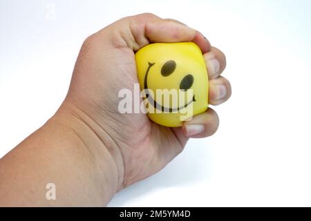 Hand squeeze yellow stress ball, isolated on white background, anger management, positive thinking concepts Stock Photo
