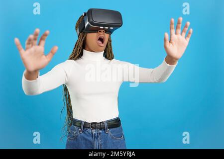 Shocked african woman wearing virtual reality goggles Stock Photo