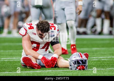 Atlanta, GA, USA. 1st Jan, 2023. Ohio State Buckeyes tight end Mitch Rossi (34) drops to the ground after losing the 2022 Chick-fil-a Peach Bowl to Georgia Bulldogs at Mercedes-Benz Stadium in Atlanta, GA. (Scott Kinser/CSM). Credit: csm/Alamy Live News Stock Photo