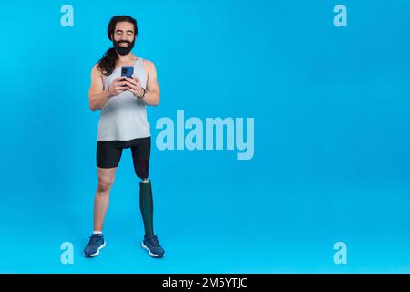 Man with a prosthetic amputated leg using a mobile phone Stock Photo
