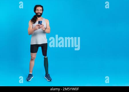 Man with a prosthetic amputated leg using a mobile phone Stock Photo