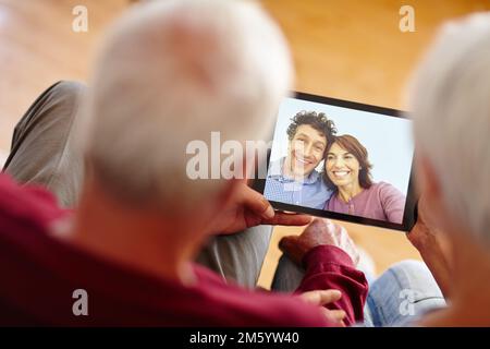 Catching up with loved ones. Over the shoulder shot of a senior couple video calling their children. Stock Photo