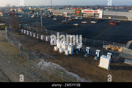 Newly installed electric vehicle charging stations and Tesla Superchargers are seen while still closed for construction on a sunny morning in Canada. Stock Photo