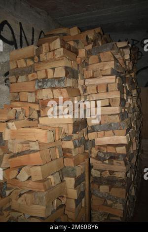 Stack of wood for burning for heating in the basement Stock Photo