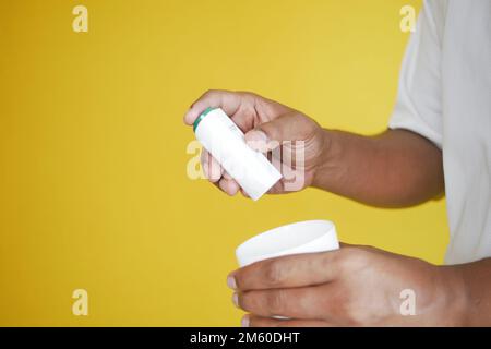 young man putting artificial sweetener in tea with copy space  Stock Photo