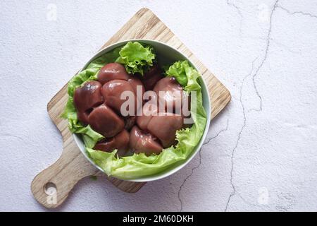 Raw fresh lamb kidneys on a chopping board  Stock Photo