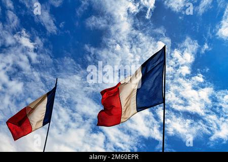 Two French national flags fluttering side by side in the wind, tricolour, slightly cloudy sky, Giverny, Eure, Normandy, France Stock Photo