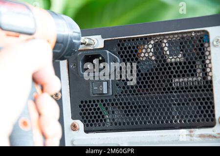 Technician screwing the back of the computer, fixing the computer Stock Photo