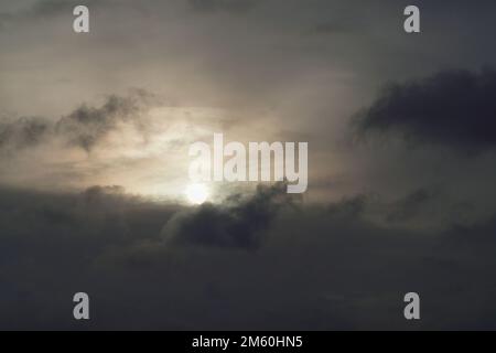 Low angle view of sunlight streaming through clouds Stock Photo