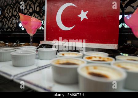 Close-up of rice pudding served in bowl on table in front of Turkish flag Stock Photo