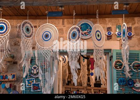 Dreamcatchers with evil eyes and feathers hanging from roof at market Stock Photo