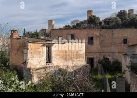 Old abandoned rural house with old stone mills in the background. Felanitx, island of Mallorca, Spain Stock Photo