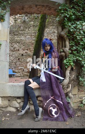 Young girls wearing a black bride like costume, warrior girl wielding a katana sword, in a medieval setting Stock Photo