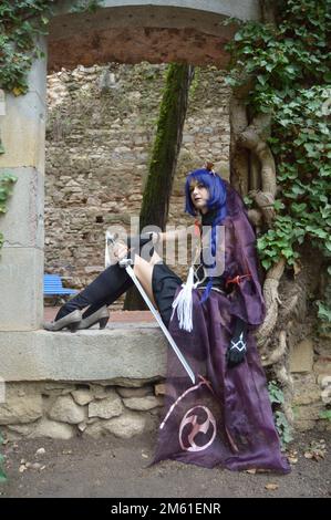 Young girls wearing a black bride like costume, warrior girl wielding a katana sword, in a medieval setting Stock Photo