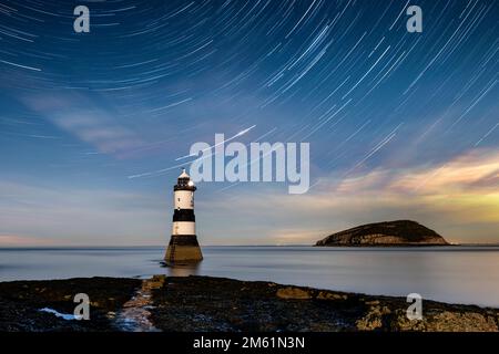 Star Trails over Trwyn Du Lighthouse and Puffin Island, Penmon Point, Anglesey, North Wales, UK Stock Photo