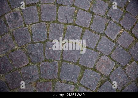 a road made of some squre stone with some dry leafs. Stone patio tiles. Texture Figured Paving Slabs. seamless texture. high resolution. Coating with Stock Photo