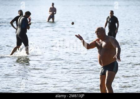 The people of Split used the sunny first day of the New Year for a picigin on Bacvice beach in Split, Croatia on January 1, 2023. Picigin is traditional ball game from Split  that is played on the beach. It is an amateur sport played in shallow water consisting of players keeping a small ball from touching the water. Stock Photo