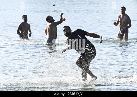 The people of Split used the sunny first day of the New Year for a picigin on Bacvice beach in Split, Croatia on January 1, 2023. Picigin is traditional ball game from Split  that is played on the beach. It is an amateur sport played in shallow water consisting of players keeping a small ball from touching the water. Stock Photo