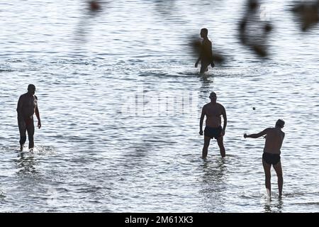 The people of Split used the sunny first day of the New Year for a picigin on Bacvice beach in Split, Croatia on January 1, 2023. Picigin is traditional ball game from Split  that is played on the beach. It is an amateur sport played in shallow water consisting of players keeping a small ball from touching the water. Stock Photo