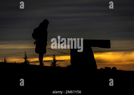 Silhouette of woman near stone table on slope near big Liberec city Stock Photo