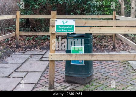 Designated smoking area sign and bin for cigarettes, UK Stock Photo