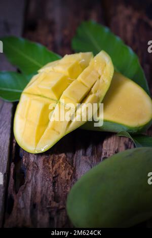 Mango fruit and mango cubes on the wooden table. Stock Photo