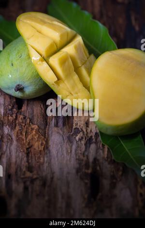 Mango fruit and mango cubes on the wooden table. Stock Photo