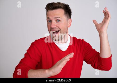 young man smiling, feeling carefree, relaxed and happy, dancing , having fun  Stock Photo