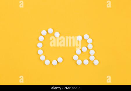 Flat lay composition with calcium supplement pills on yellow background. Stock Photo