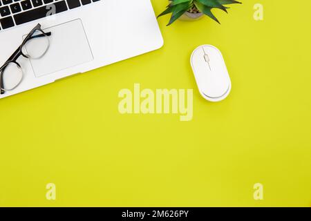 Laptop, glasses and computer mouse on green background, flat lay. Stock Photo