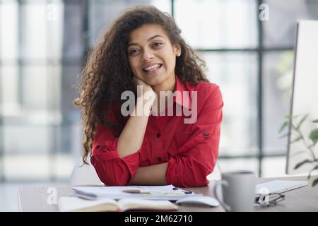 Photo of joyful nice woman using laptop and smiling while sitting Stock Photo