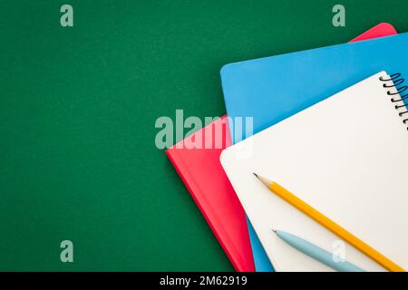 Notebooks on green background, school concept, flat lay. Stock Photo
