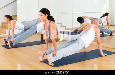 Couples practicing yoga with partner at studio Stock Photo