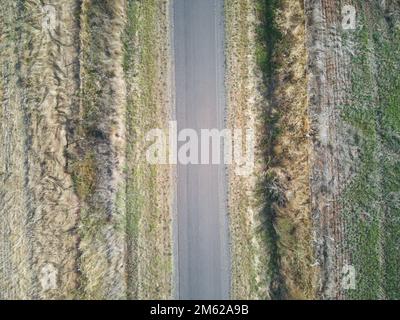 Empty road aerial view showing asphalt surface and green edge fields on each side. Victoria, Australia. Stock Photo