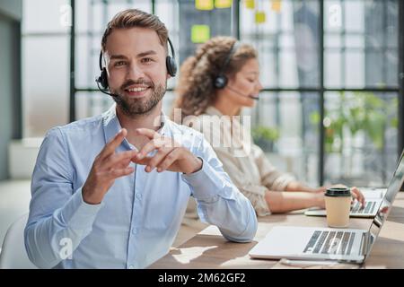 Customer Service Representative With Colleague Working In Office Stock Photo