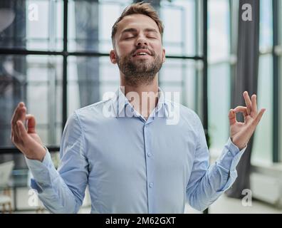 Young worker having break and resting after solving task Stock Photo