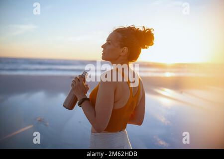 fit woman jogger in sport clothes drinking water. Stock Photo