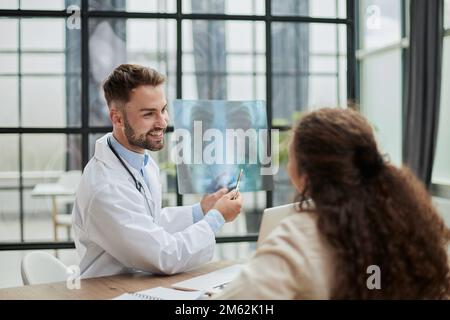 Concentrated male doctor looking at x-ray picture of spine Stock Photo