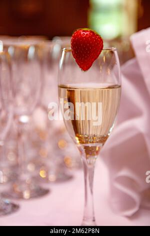 Tall glass with sparkling wine champagne and strawberries, wedding Stock Photo