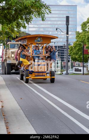 Female tourists pedal a multi-passenger human-powered bar on wheels on a fun, celebratory tour in downtown Nashville, Tennessee. Stock Photo