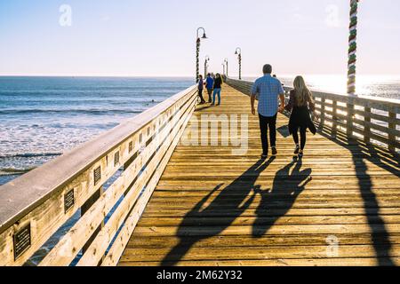 Cayucos, California, USA- December 25, 2022. A long wooden pier, and walking people. Cayucos pier, California Central coast Stock Photo