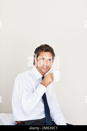 Smiling man having a cup of coffee. Mature man having a cup of coffee and smiling. Stock Photo