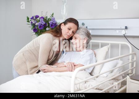 Well get the best doctors. An affectionate daughter hugging her sick mother in the hospital. Stock Photo