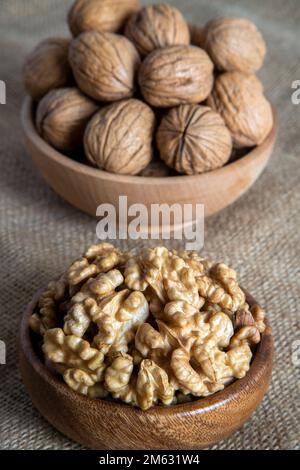 Peel walnuts and whole walnuts on burlap sack,closeup Stock Photo