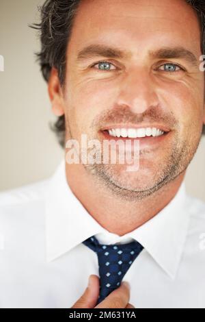 Smart mature man wearing tie. Closeup of smart mature man wearing tie and smiling. Stock Photo