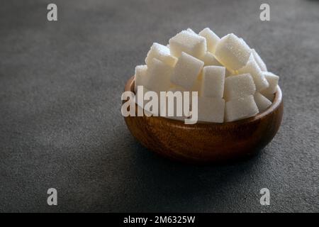 White sugar cubes in bowl on a dark background Stock Photo