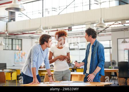 Getting into the details. a group of colleagues collaborating with each other on a project in an office. Stock Photo