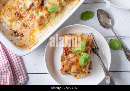 Lasagna with cannelloni, bolognese and bechamel sauce with mozzarella cheese topping on white background. Flat lay Stock Photo