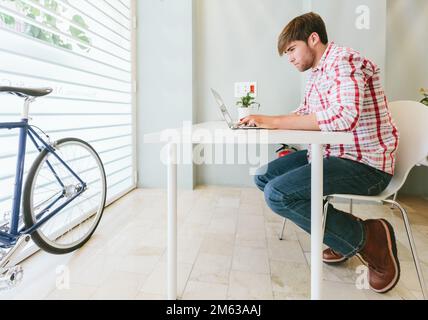 Young Man Working at the Office with a laptop Stock Photo